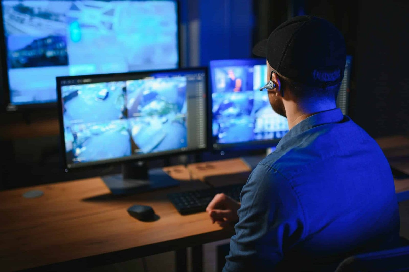 Male security guard monitoring modern CCTV cameras indoors